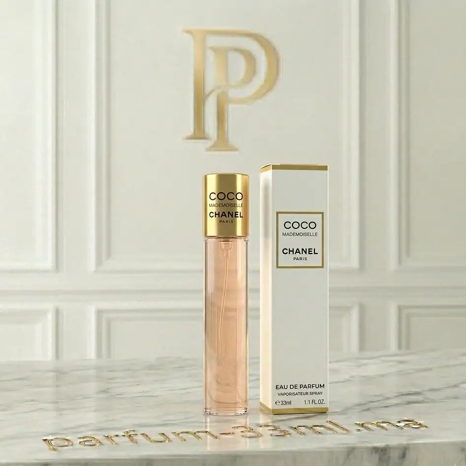 Flacon de parfum 33ml Coco Mademoiselle avec son bouchon doré poli et sa boîte blanche aux liserés or sur un comptoir en marbre blanc luxueux.