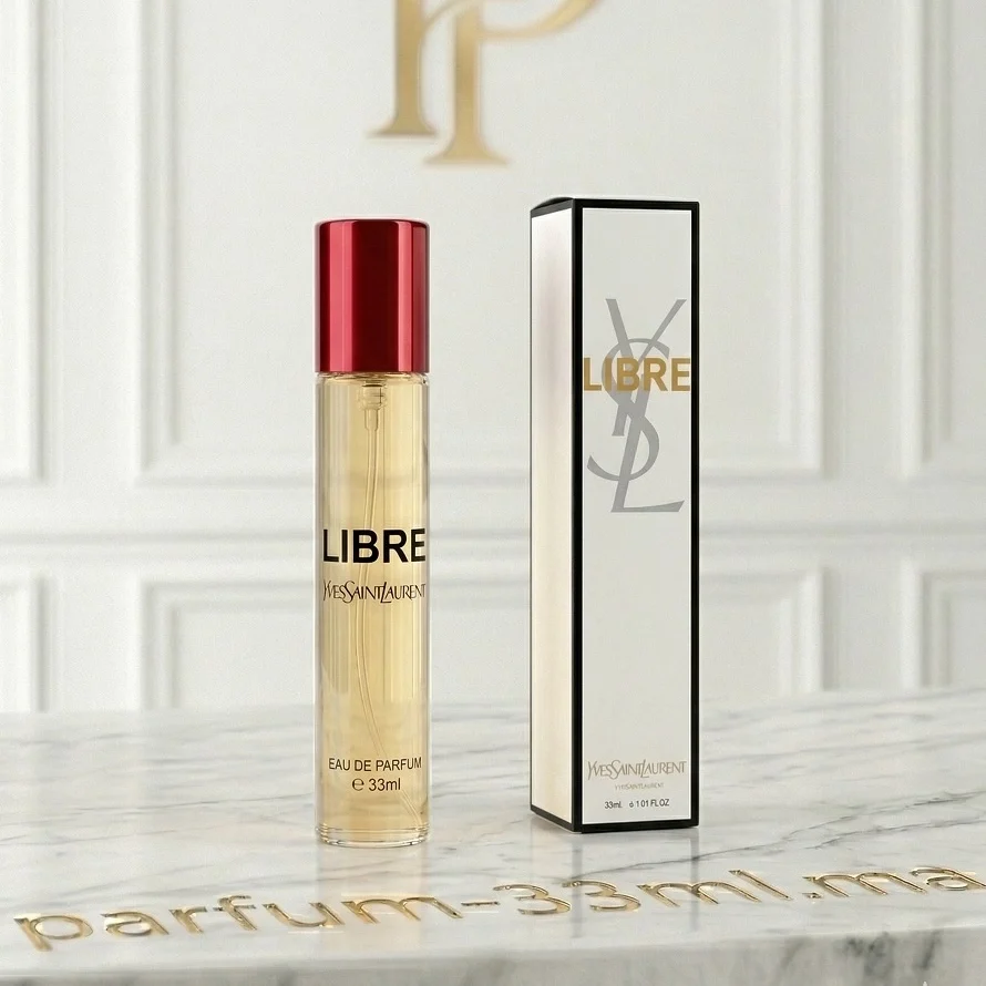 Flacon d'extrait de parfum 33ml Libre Yves Saint Laurent avec son bouchon rouge poli et sa boîte d'origine sur un comptoir en marbre Carrara blanc.