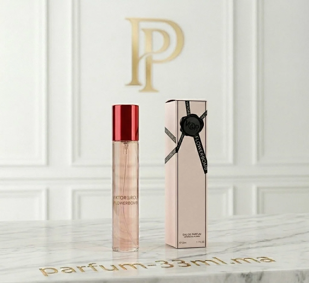 Flacon de parfum 33ml Flowerbomb de Viktor & Rolf avec son bouchon rouge poli et sa boîte rose poudré sur un support en marbre blanc épuré.